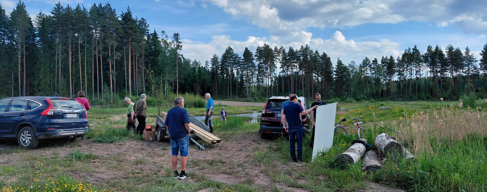 Talkooporukka suunnittelee, miten kosteikkotaulu pystytetään. Kosteikkotaulu